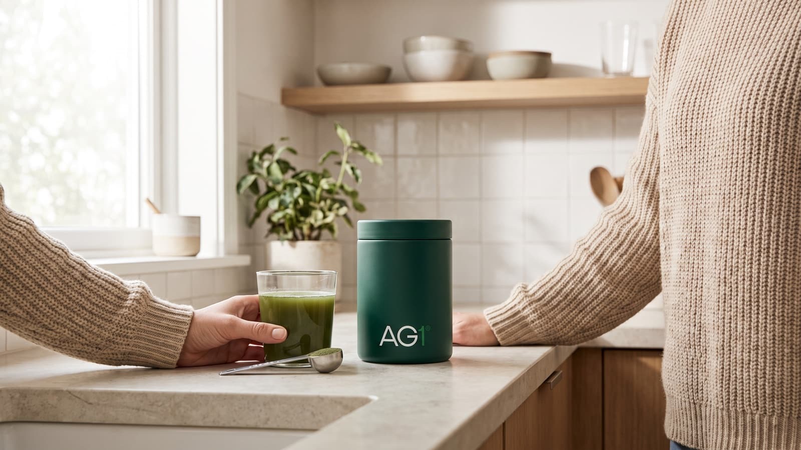 A green AG1 nutrient drink and the AG1 canister on a bright kitchen countertop in morning light