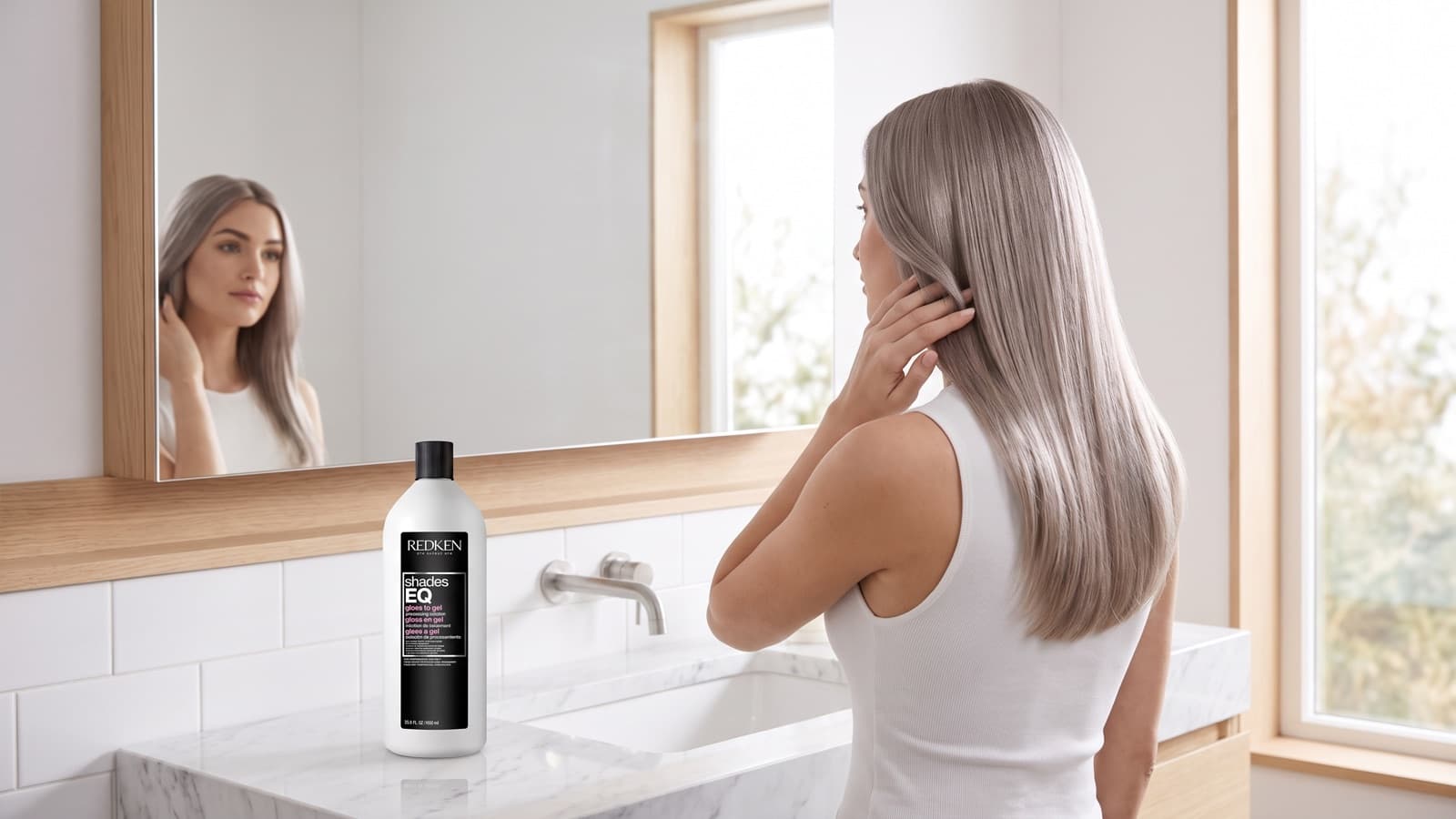 Woman with cool-toned ash blonde hair in a bright minimalist bathroom